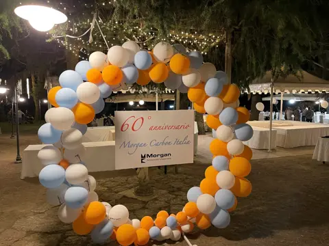 Blue white and orange ballon arch infront of white marquees with tables set up