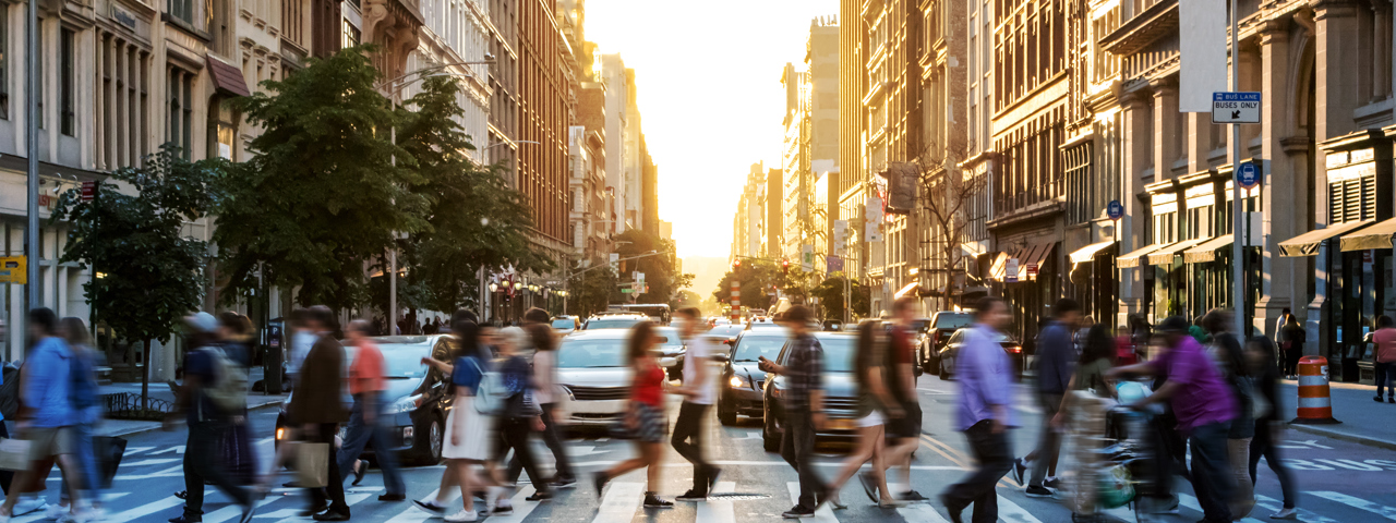 Blurred image of people crossing wide new york road in summer clothing