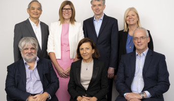 Seven people in business clothing; four men and three women