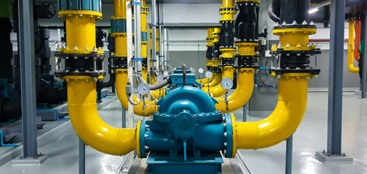 Yellow and blue pump pipes inside pump room
