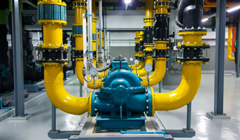 Yellow and blue pump pipes inside pump room