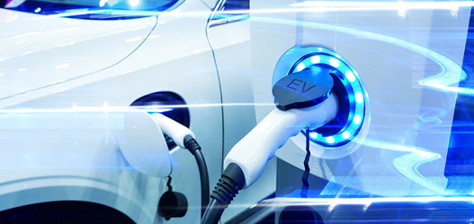 White electric vehicle attached to blue light up electric vehicle charge point